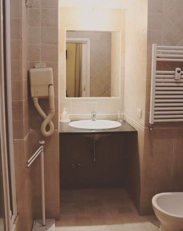 Bagno con doccia e sanitari in ceramica bianca