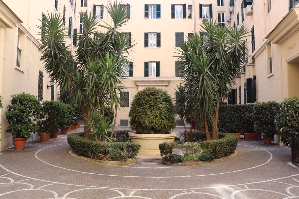 Cortile con palme di fronte all'edificio del bed and breakfast