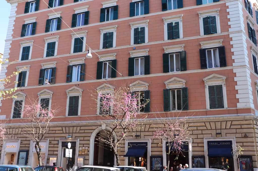 Grande edificio in mattoni con auto parcheggiate di fronte, in zona Prati a Roma